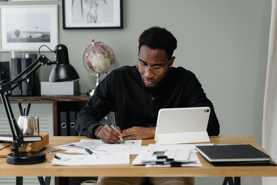 Businessman in a modern office working on documents using a digital tablet.